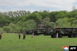 Pemimpin Korea Utara Kim Jong Un (kiri tengah) mengamati latihan serangan balik nuklir secara virtual dengan unit "artileri roket" yang besar. (Foto: AFP)