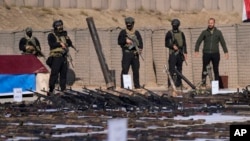 Anggota Pasukan Mobilisasi Populer (PMF) menunjukkan senjata yang mereka sita dari para anggota militan ISIS di provinsi Salahuddin, di utara Baghdad, Irak, pada 12 Januari 2023. (Foto: AP/Hadi Mizban)