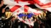 Demonstran mengibarkan bendera saat unjuk rasa memprotes RUU tentang "agen asing" di Tbilisi, Georgia, 13 Mei 2024. (Foto: REUTERS/Irakli Gedenidze)